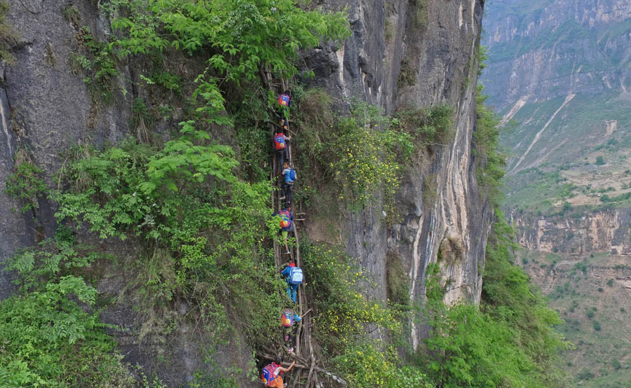 Kids climb vine ladder in 'cliff village' in Sichuan