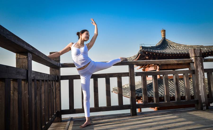 Striking yoga poses on top of cliff