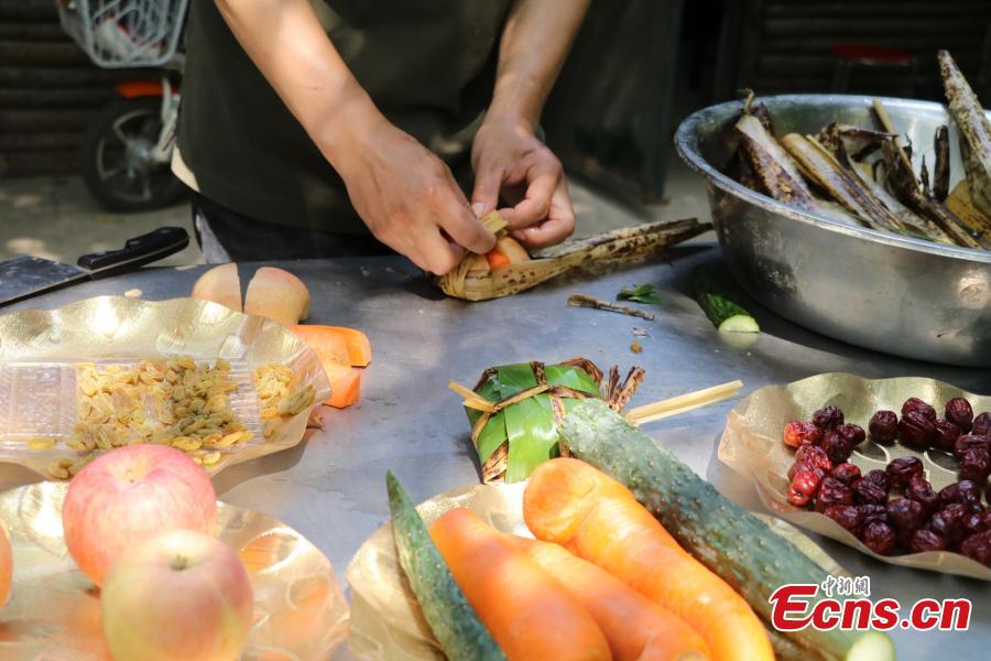 Giant panda enjoys <EM>zongzi</EM> at zoo in Yangzhou