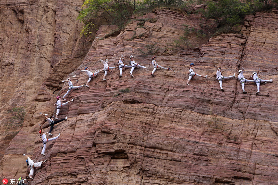 High on mountain: Yoga enthusiasts practice on cliff