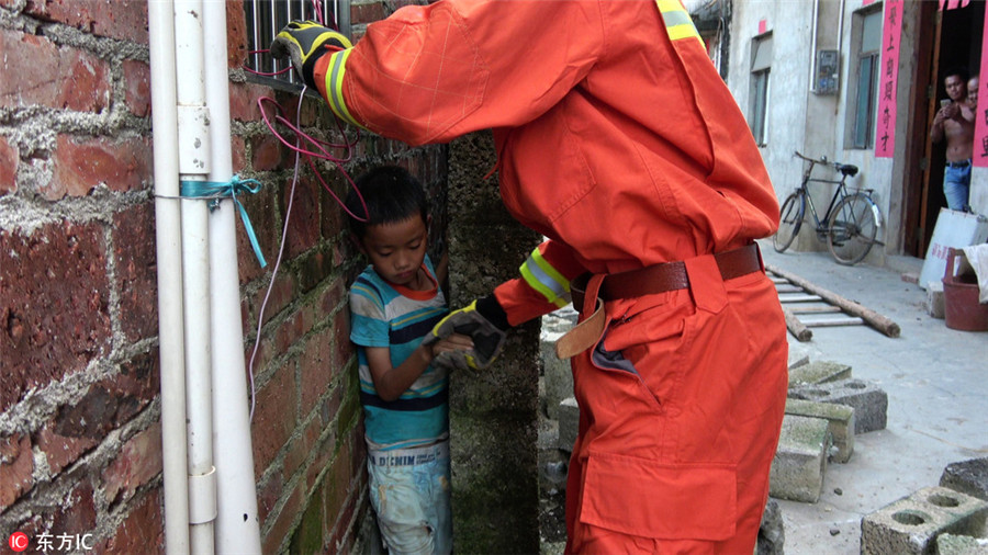 Left-behind boy gets stuck in 20-cm-wide gap