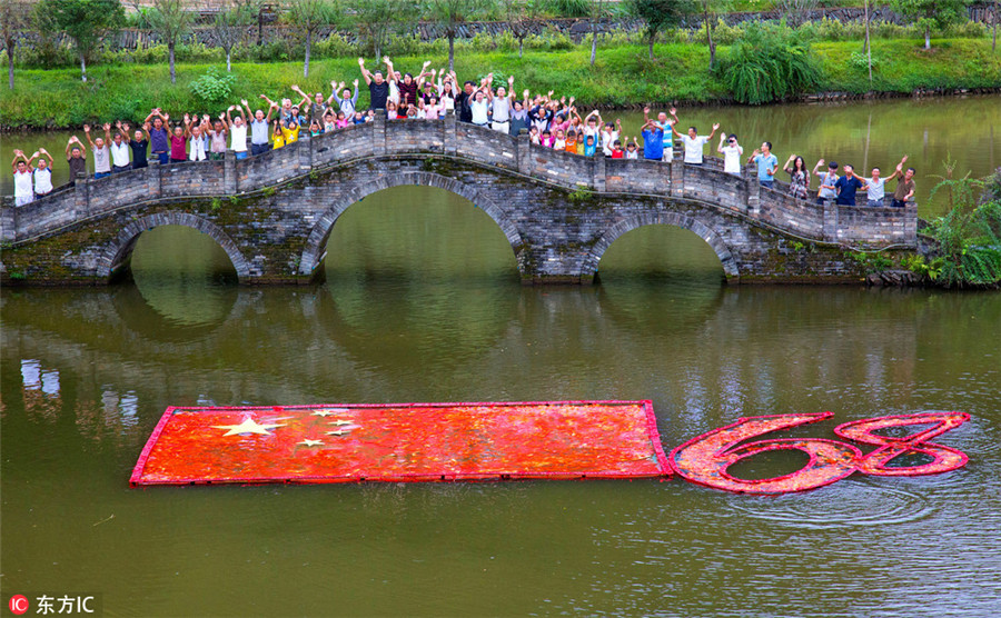 Farmers 'draw' love to motherland with red carps in river