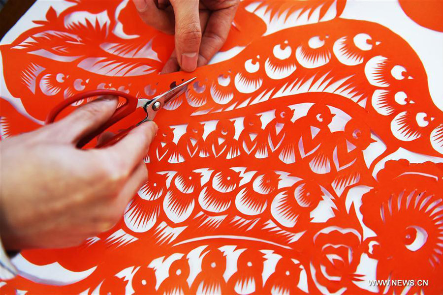 Chinese folk artist makes papercutting works to mark Spring Festival