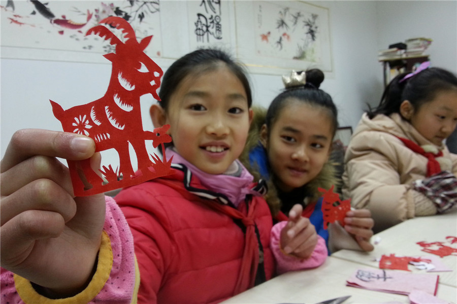 Students create paper-cut art in E China