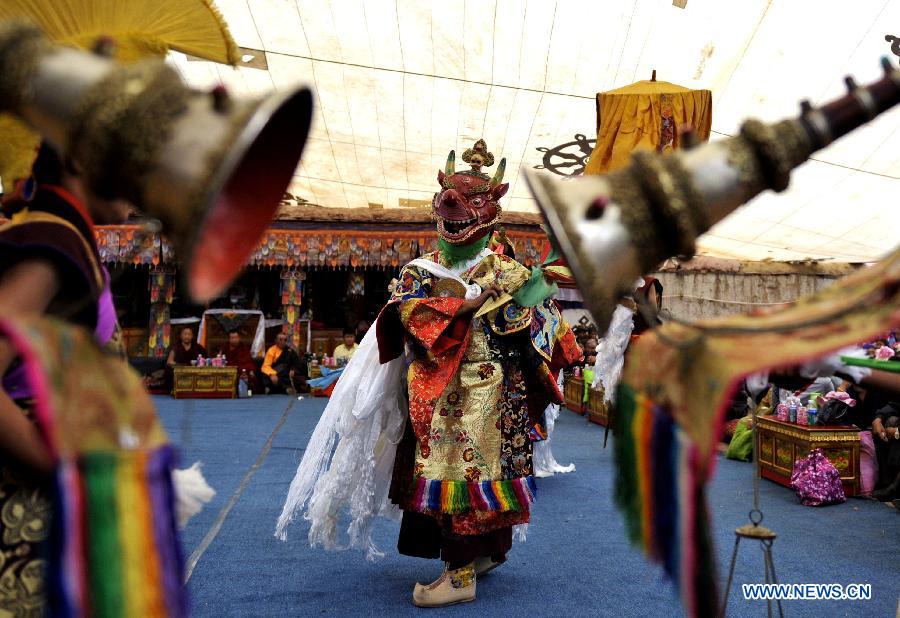 Tibetan Buddhist monks perform cham dance during ritual