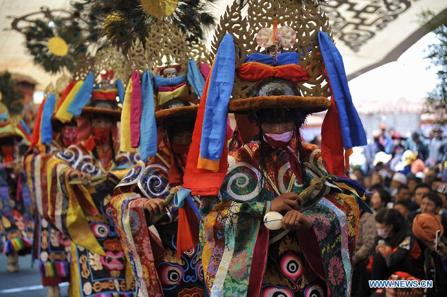 Tibetan Buddhist monks perform cham dance during ritual