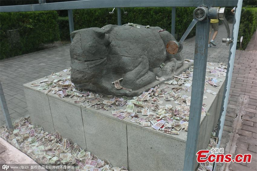 Tourists toss notes at cultural relic for luck