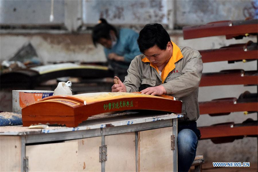 Workers make Chinese traditional music instruments Guzheng in Henan