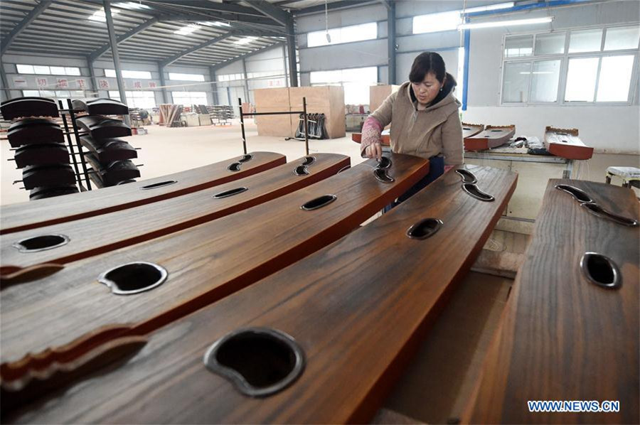 Workers make Chinese traditional music instruments Guzheng in Henan