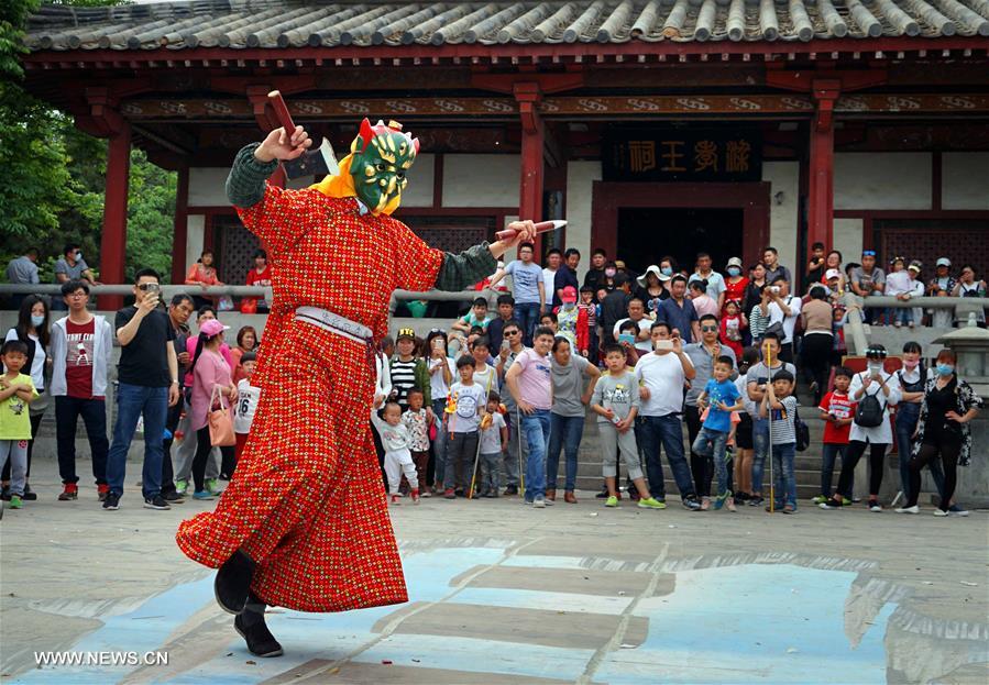 Tourists view Nuo dance at China's Yongcheng