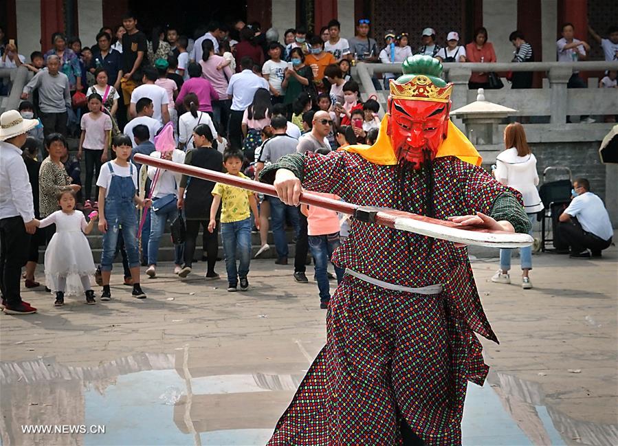 Tourists view Nuo dance at China's Yongcheng