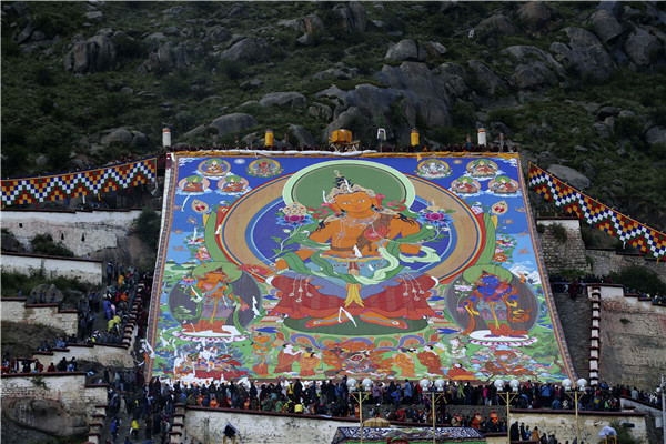 Thangka adorns hillside during Shoton