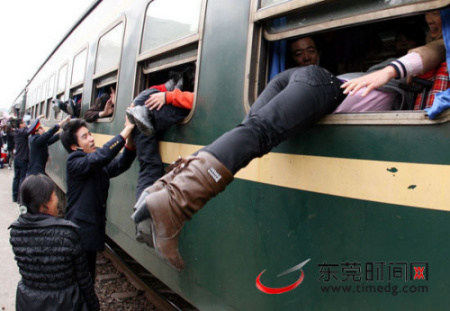1月25日下午,东莞东火车站。虽然春运还未到,但已有大批的回乡的旅客。图为一些乘客从车窗爬上列车,工作人员协助。(记者 郑琳东 摄)(以上图片均为郑琳东当日在东莞东站所拍)(以上图片均为郑琳东当日在东莞东站所拍) “爬窗门”事件沸沸扬扬 拍照记者首次正面回应