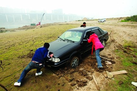 情侣长江边晒太阳 车陷淤泥“无法自拔”