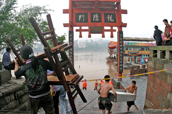 Residents in Chongqing of Southwest China prepare for normal life Wednesday as floodwaters continue to recede. Medical workers have started disinfection work in the flood-hit areas. [newsphoto]