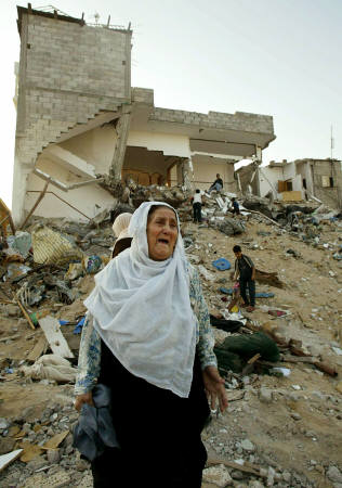 A Palestinian woman cries near the rubble of her destroyed home in the Jabalya refugee camp northern Gaza Strip October 16, 2004.[Reuters]