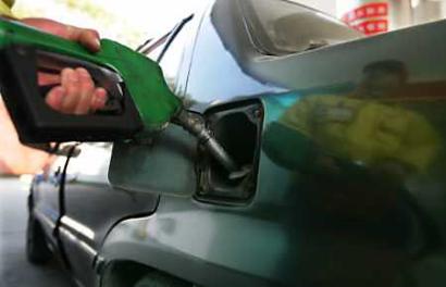A worker pumps fuel into a vehicle at a gas station in Beijing, October 27. [Reuters]