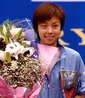 Zhang Yining of China holds the trophy and a bouquet of flowers after beating compatriot Wang Nan in the Women's Singles at the Bosideng Multiglory ITTF World Cup in Xiaoshan of East China's Zhejiang Province on Sunday. [Xinhua] 
