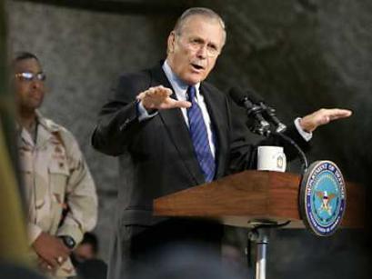 U.S. Secretary of Defense Donald Rumsfeld addresses U.S. military personnel in Kuwait before their scheduled departure for Iraqi combat-zones, December 8, 2004. An American soldier complained to Rumsfeld that troops were being forced to dig up scrap metal to protect their vehicles in Iraq because of a shortage of armored transport. [Reuters]