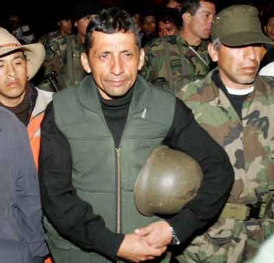 Former army Major Antauro Humala (2nd L) is escorted by Peruvian soldiers before meeting in the southern Andean town of Andahuaylas, January 3, 2005. Peruvian authorities arrested a former army major who led a three-day uprising in a southern Andean town and vowed on Tuesday to storm the police station where his followers remained holed up unless they surrendered soon. [Reuters]