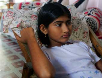 Almas, a twelve-year-old Indian girl, rests at her relatives' house in Port Blair January 5, 2005 after she was rescued by soldiers on Monday on the remote Indian island of Nacowrie in the southern part of the Andaman and Nicobar archipelago. Almas said that her parents and sister were swept away by the killer waves December 26.