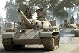 Iraqi army tanks roll past Iraqi Interim Premier Ayad Allawi, not seen, during a military parade at the al-Taji base, north of Baghdad, Iraq, Thursday, Jan. 6, 2005. [AP]