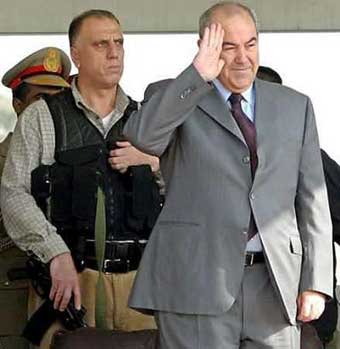 Iraq's Interim Prime Minister Iyad Allawi salutes as he stands next to a bodyguard during a military parade north of Baghdad, January 6, 2005. Iraq's U.S.-backed government said on Thursday it was extending emergency powers equivalent to martial law for a further 30 days to try to safeguard Jan. 30 elections under threat from deadly attacks by insurgents. [Reuters]