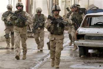 U.S. Army 1st Battalion, 24th Infantry soldiers return to their vehicles after hearing a large, distant explosion in Mosul, Iraq, Saturday, Jan. 15, 2005. A roadside bomb had struck another Army convoy across the city. [AP]
