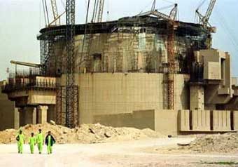 Workmen wearing protective clothing walk away from the Russian-built Bushehr nuclear power reactor under construction in southwestern Iran during an organized media visit to the plant on March 11, 2003. US President Bush said on Monday he would not rule out military action against Iran if that country was not more forthcoming about its suspected nuclear weapons program. [Reuters]