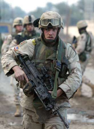 U.S. troops from the 1st Infantry Division patrol the streets during an early morning raid in Khatoon, a suburb of the Iraqi town of Baquba on January 19, 2005. REUTERS/Nikola Solic 