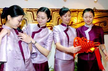 Air China stewardesses try on their new cheong-sam uniform, specially designed for the nonstop cross-Straits flights during the Spring Festival in Beijing January 27, 2005. [newsphoto]