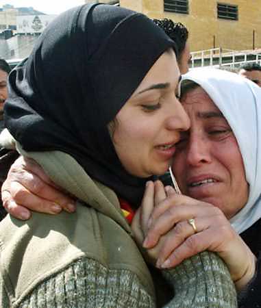 Released female Palestinian prisoner Ameera Abu Thraa (L) is kissed by her mother in the West bank city of Nablus, February 21, 2005. Israel freed 500 Palestinian prisoners in the largest mass release in nearly a decade, a gesture meant to bolster a ceasefire deal with new Palestinian President Mahmoud Abbas. (Abed Omar Qusini/Reuters) 