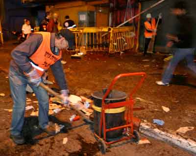Israeli workers clean the scene of a suicide blast in Tel Aviv early February 26, 2005. [Reuters]