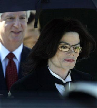Followed by one of his defense attorney, Brian Oxman, left, Michael Jackson appears at the Santa Barbara County Superior Court after the first day of his child molestation trial Monday, Feb. 28, 2005, in Santa Maria, Calif. The prosecution and defense teams presented their opening statements to the judge and jury on the first day of the trial. [AP] 