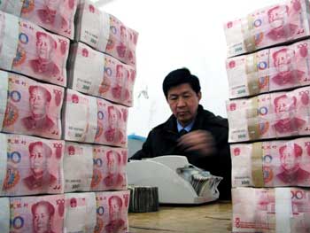 A clerk with Hai'an sub-branch of China Construction Bank in Jiangsu Province counts the 100-yuan banknotes in this March 2, 2005 photo. Guo Shuqing, China's foreign exchange administrator, said China will maintain the current foreign-exchange system but will allow the market to play an increasingly larger role in determining the renminbi's rate. [newsphoto]