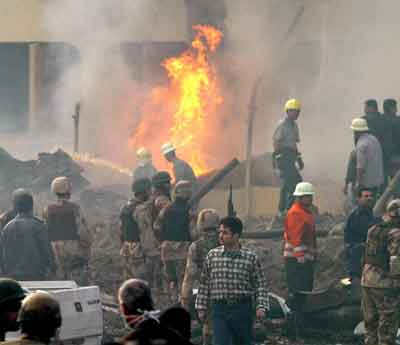 Iraqi authorities arrive at the scene after a powerful suicide bomb exploded in central Baghdad early March 9, 2005. A suicide bomber driving a garbage truck blew himself up on Wednesday near a Baghdad hotel used by Iraqi police and their foreign instructors, police said. [Reuters]