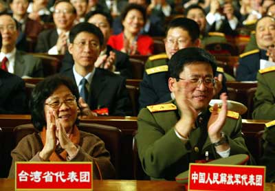 legislators from the military (R) and Taiwan (L) applaud after the passing of an anti-secession law during the closing of the annual session of the National People's Congress at the Great Hall of the People in Beijing March 14, 2005. China's top legislature adopted the Anti-Secession Law Monday, with 2,896 deputies voting for the law, no objections and two abstentions. 