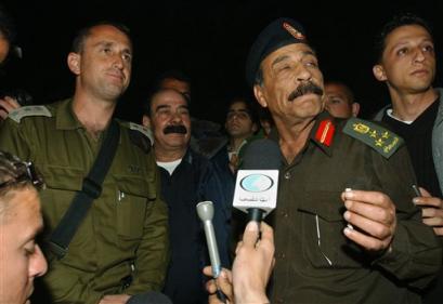 Palestinian police officer Said Abu Pasha, right, and Israeli commander of Tulkarem area Col. Tamir Hayman speak to the press after a meeting at the District Coordination Office in the West Bank town of Tulkarem Monday March 21, 2005. [AP]