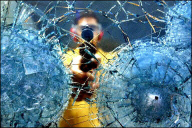 A worker is seen testing security glass against gunfire. At least four people were killed and more than a dozen others were injured in a school shooting in Minnesota, according to local media reports.(AFP/File/Mauricio Lima)