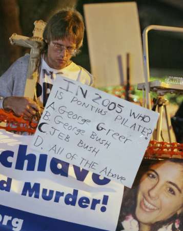 Protester Jeff Asmussen, of Silver Bay, Minnesota, is all alone as he keeps a vigil outside the Woodside Hospice, where brain damaged Florida woman Terri Scghiavo is being cared for, in Pinellas Park, Florida, early March 27, 2005. A wrenching dispute over the fate of Schiavo neared its end Sunday as she moved closer to death and her parents gave up their long and bitter legal battle to prolong her life. REUTERS/Bob Jordan