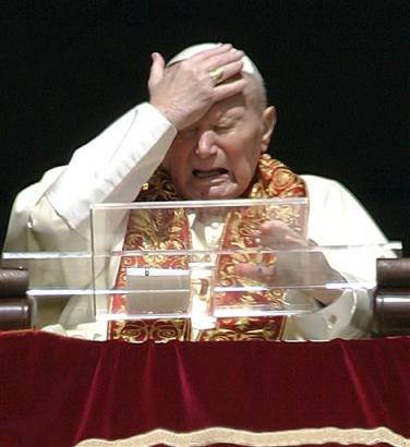 Pope John Paul II touches his head as he appears from his studio's window overlooking St. Peter's Square at the Vatican to deliver the Easter Sunday blessing, in this March 27, 2005 file photo. As Pope John Paul II struggles with his latest health crisis, a new image of his papacy is emerging, one based on gestures, images and video appearances. (AP Photo/Pier Paolo Cito/File) 