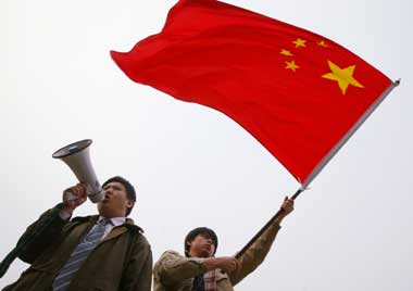 A Chinese demonstrator shouts anti-Japanese slogans as another waves a Chinese national flag during a protest against Japan's bid for a permanent seat in the United Nations Security Council in Beijing March 31, 2005 . 