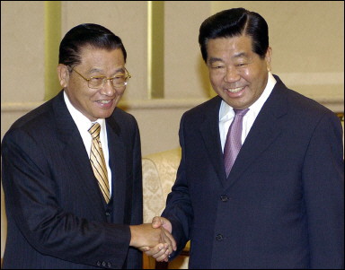 Taiwan KMT party vice chairman Chiang Pin-Kung, on the left, shakes hands with Jian Qinglin, chairman of China's CPCCC. The leader of the KMT, Lien Chan, is expected to follow Chiang with a visit to the mainland in May.(AFP Files/Takanori Sekine) 