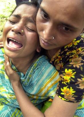 An unidentified relative of a worker trapped in a collapsed garment factory cries at Savar, an industrial town, 32 kilometers (20 miles), northwest of Dhaka, Bangladesh, Tuesday, April 12, 2005. Rescuers used their bare hands, crow bars and hammers Tuesday to reach 200 people still trapped inside the concrete debris of a nine-story garment factory that collapsed after a boiler explosion, as the death toll climbed to 30, police said. (AP Photo/Pavel Rahman) 