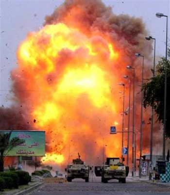 A car bomb explodes, detonated by U.S. troops after it was discovered at the scene of the double car bombing in Baghdad, Iraq Thursday, April 14, 2005. The initial attack killed 18 and wounded three dozen, but no one was injured in this controlled explosion. The sign at left reads 'Keep Your City Clean' in Arabic.(AP