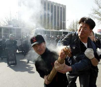 A plainclothes policeman (R) scuffles to take a firework away from former South Korean commandos trained to infiltrate into North Korea during an anti-Japan protest near the Japanese embassy in Seoul April 15, 2005. Dozens of former commandos rallied on Friday against Japan's approval of its history textbook that critics say whitewashes Japanese militarism and its claims over a group of disputed islets, referred to as Tokto in Seoul and as Takeshima in Tokyo. REUTERS/Lee Jae-Won 