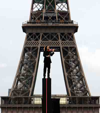 A violinist performs in front of the Eiffel tower during the commemorations of the national day of remembrance for the victims and heroes of deportation, which is part of the 60th anniversary of the liberation of the concentration camps, in Paris April 24, 2005. [Reuters]