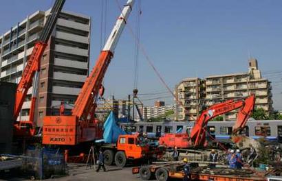 Heavy machines are used to remove wreckage of a derailed commuter train April 27, 2005, at the site of the train that smashed into an apartment building in Amagasaki in western Japan.