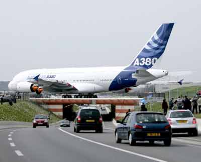 The world's biggest airliner, Airbus A380, a 555-passenger superjumbo twin deck aircraft crosses over a road on the day of its maiden flight at the Toulouse-Blagnac airport in southwestern France, April 27, 2005. [Reuters]