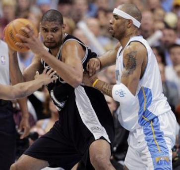 San Antonio Spurs forward Tim Duncan, left, turns to work the ball inside against Denver Nuggets forward Kenyon Martin in the first quarter of Game 4 of their NBA Western Conference first-round series in Denver on Monday, May 2, 2005. (AP